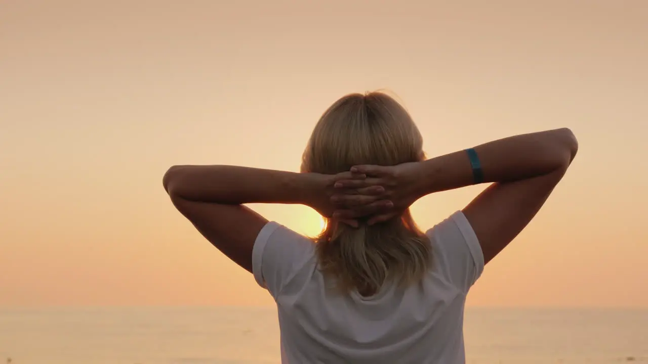 A Young Fair-Haired Tourist Meets The Dawn On The Seashore Relaxes Enjoys The Silence View From The 