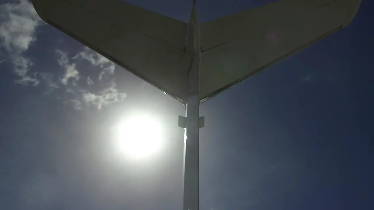 Steadi cam shot underneath tail of private plane with light flare