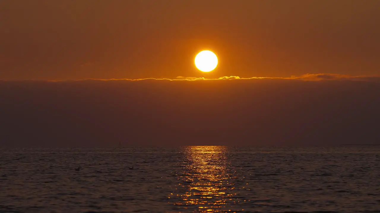 Sun up in the sky during the sunset with ocean seascape view illuminated with golden hour