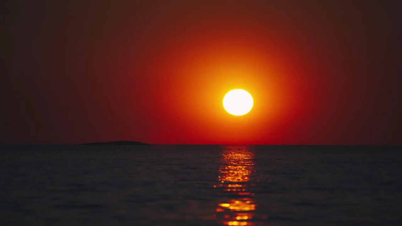 The sun is setting over the horizon at a beach at the Croatian Mediterranean seaside