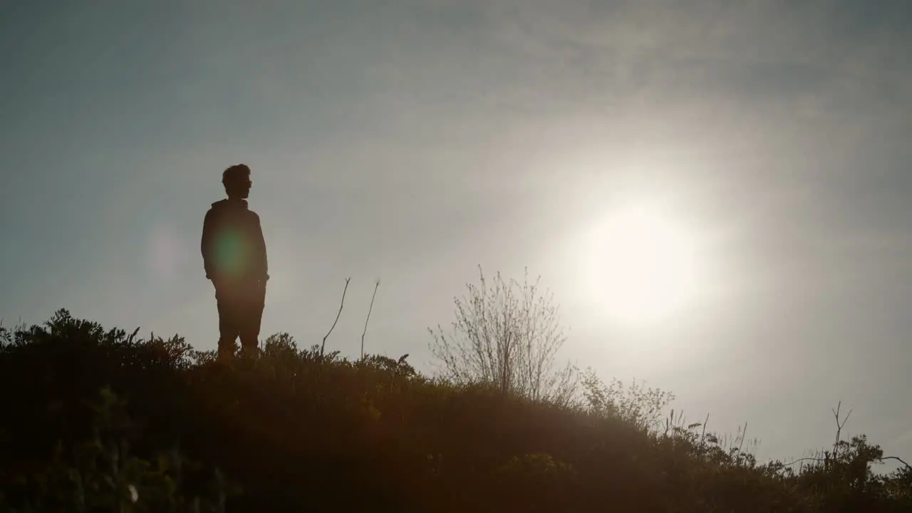 Man looking in the valley  silhouette effect big sun clear sky