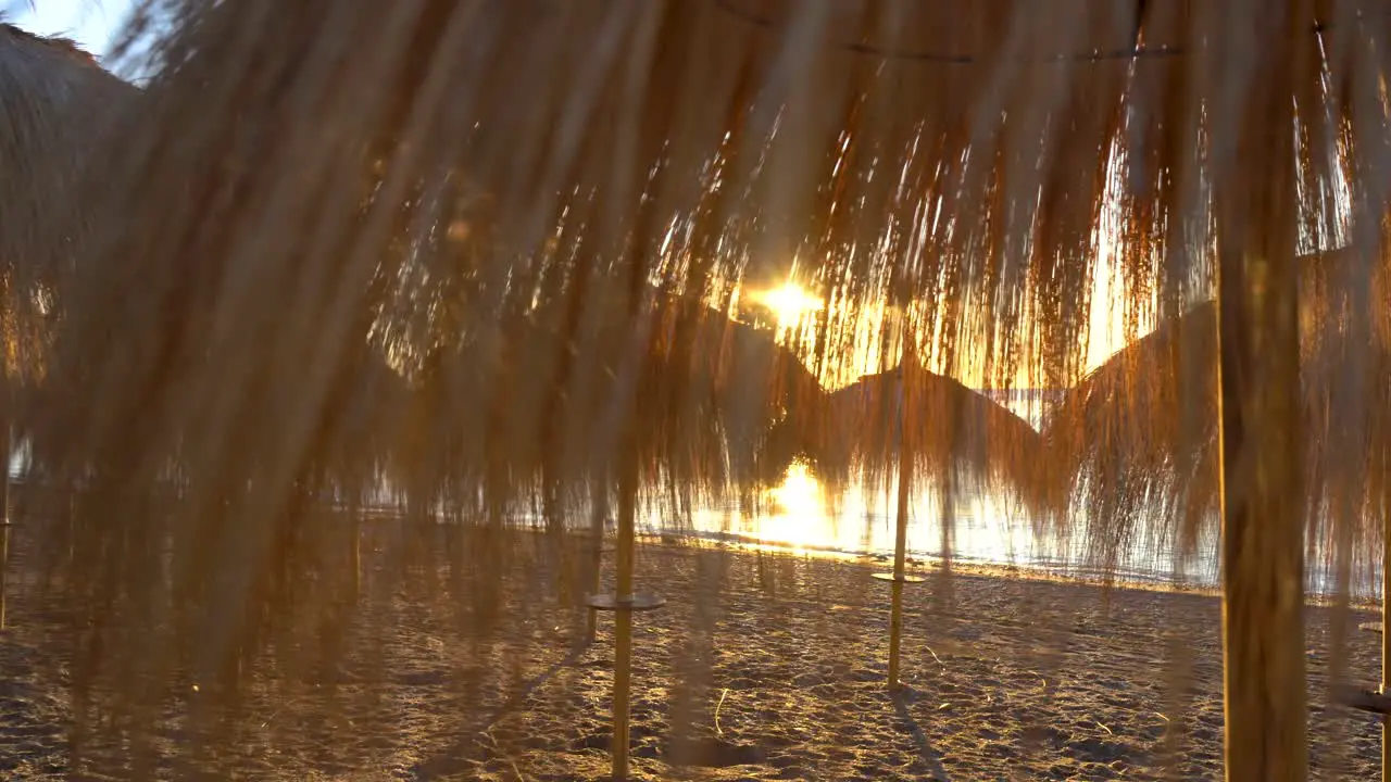 sunrise marbella beach gimbal smooth movment through straw parasols 4k