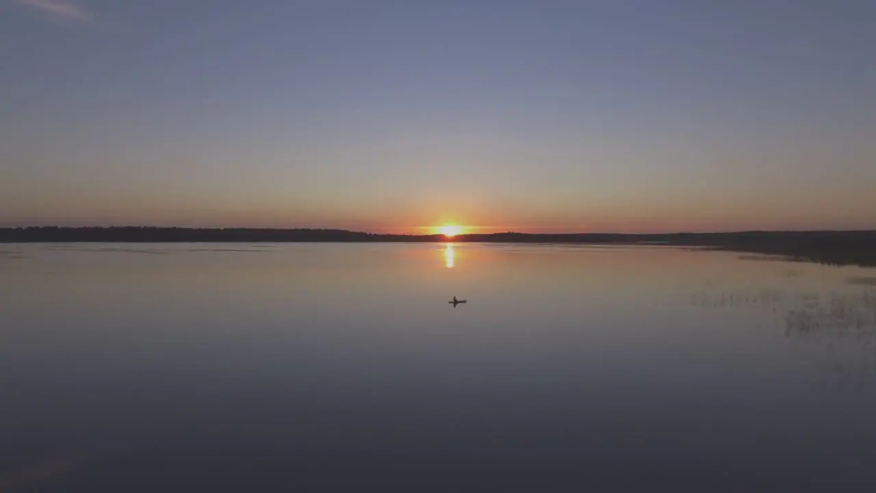 Aerial Flying Over Fisherman in a Boat on a Lake on a Calm Summer Evening at Sunset