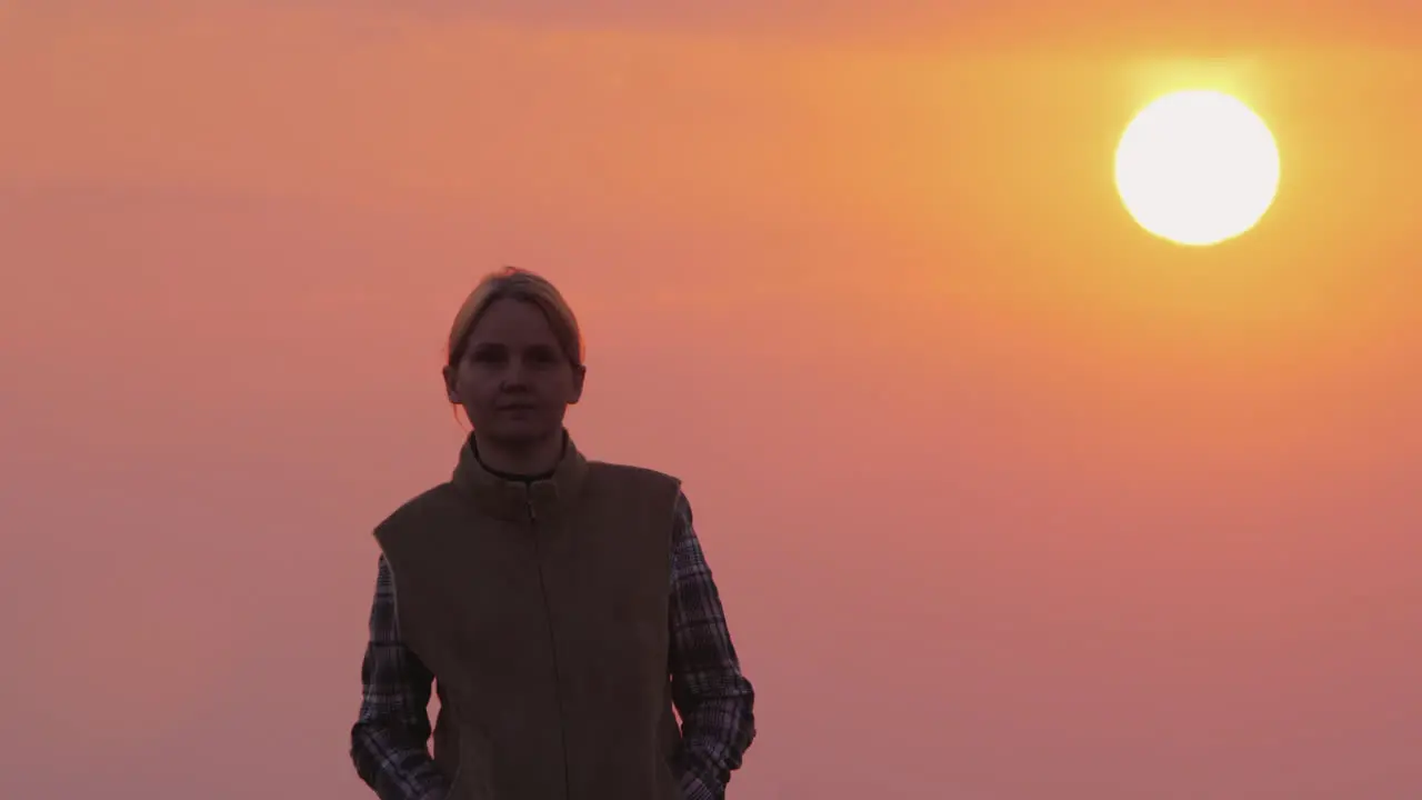 A Woman Goes Forward Against The Pink Sky And The Setting Sun