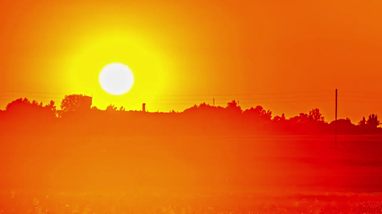 Fiery golden glowing sunset on a hazy evening in the countryside time lapse