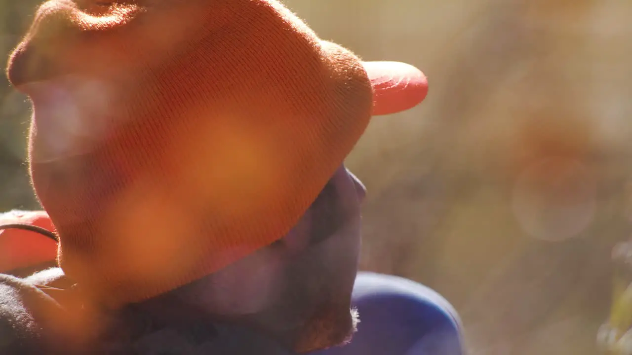 Hunter waits in field wearing hunters orange