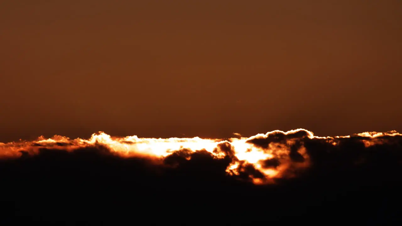 telephoto sunrise with orange sun creeping over clouds 8k timelapse