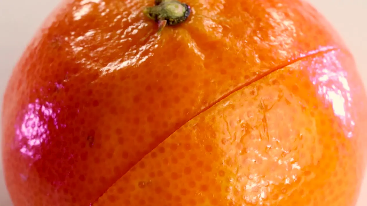 Very sharp knife cutting the surface of a tangerine