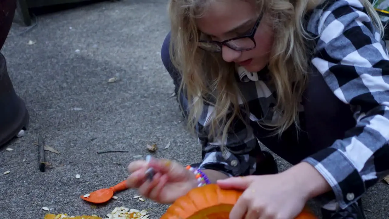 Cute Blondie Girl Painting With Black Pen On Orange pumpkin Halloween