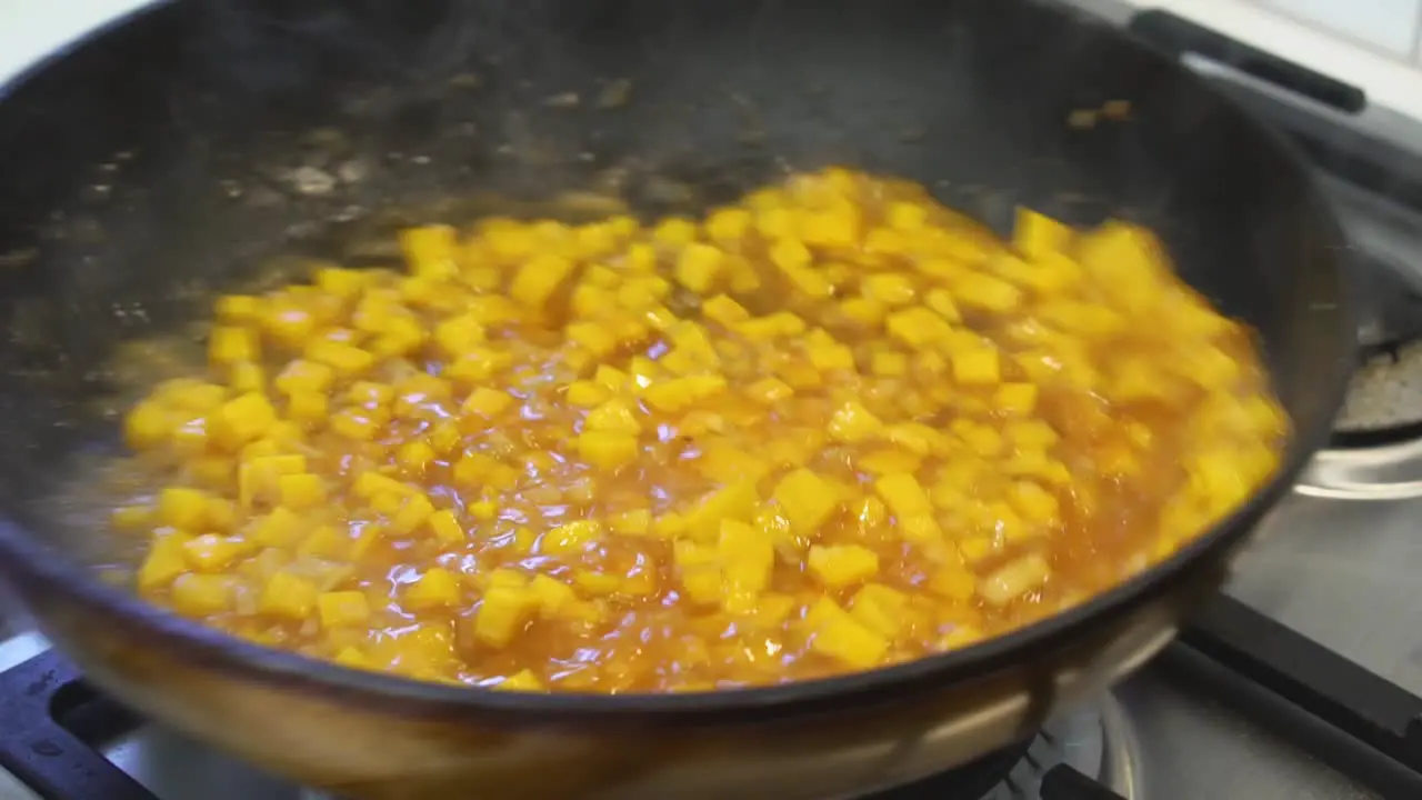 Shaking pumpkin risotto to mix with rich sauce while cooking