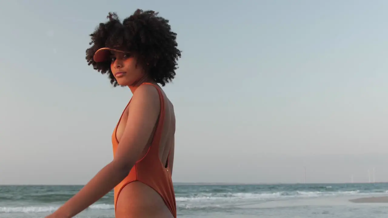 Young girl with curly afro hair walking on a beach