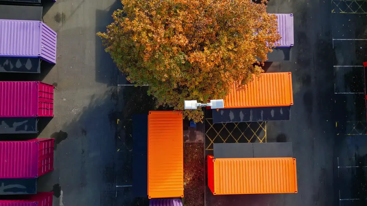 Aerial footage of multicolored porta cabins market stalls steel cabins storage units shot from directly above and moving slowly backwards