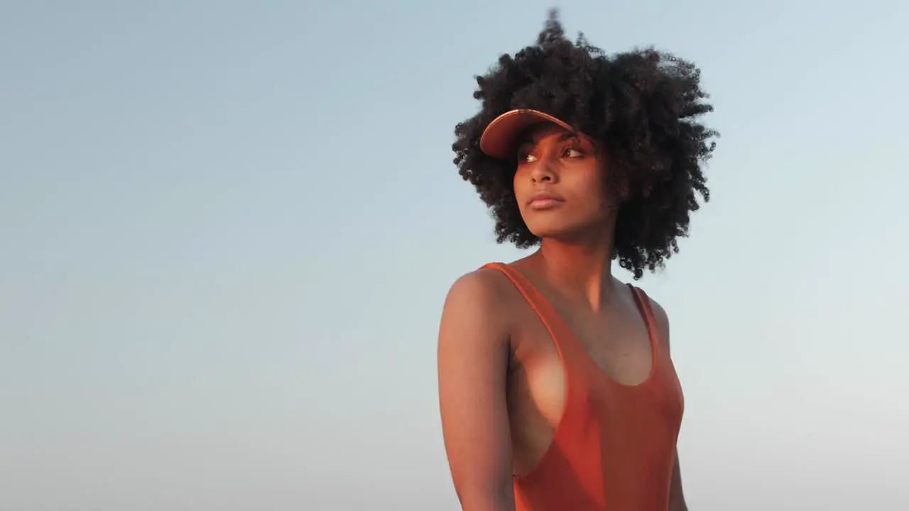 Girl with curly afro hair walking on a beach