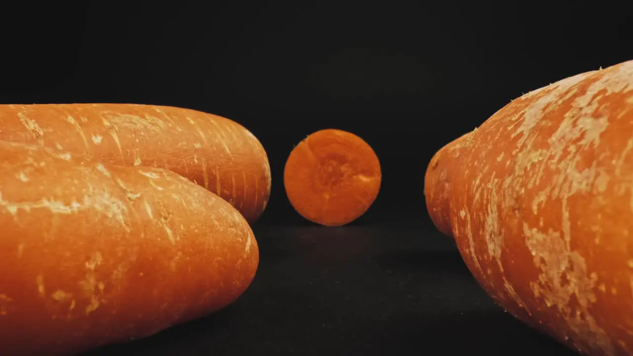 Macro push in of carrot piece in a black background using a probe lens