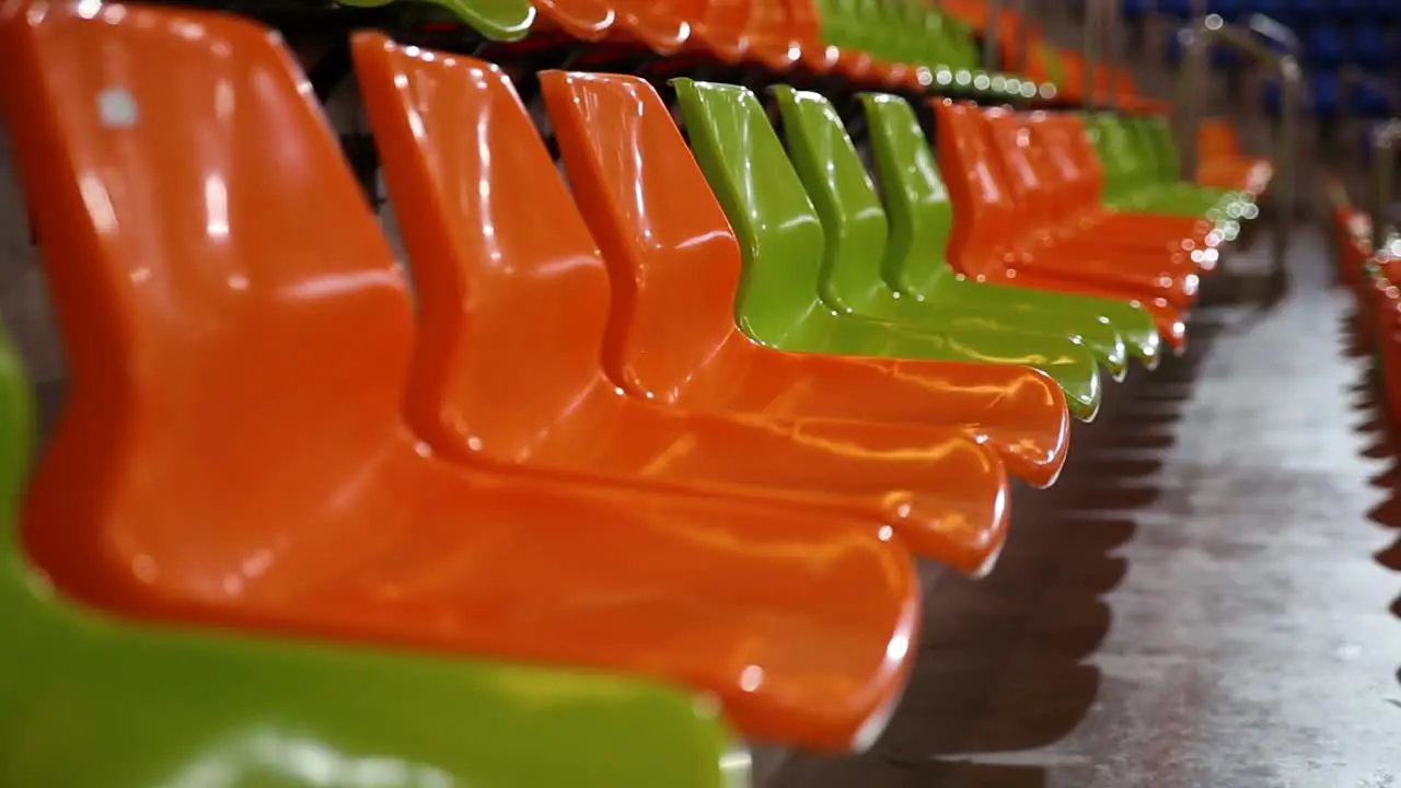 Rows of green and orange stadium chairs