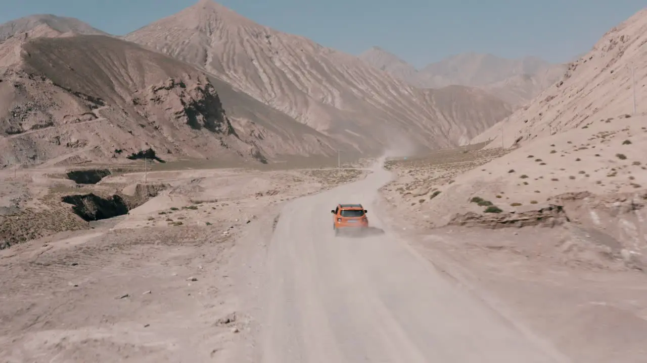 Roadtrip on dusty canyon road in Qinghai Province China aerial follow shot