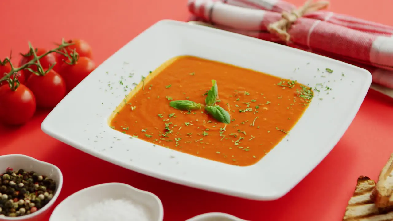 Tomato soup in plate with green leaf