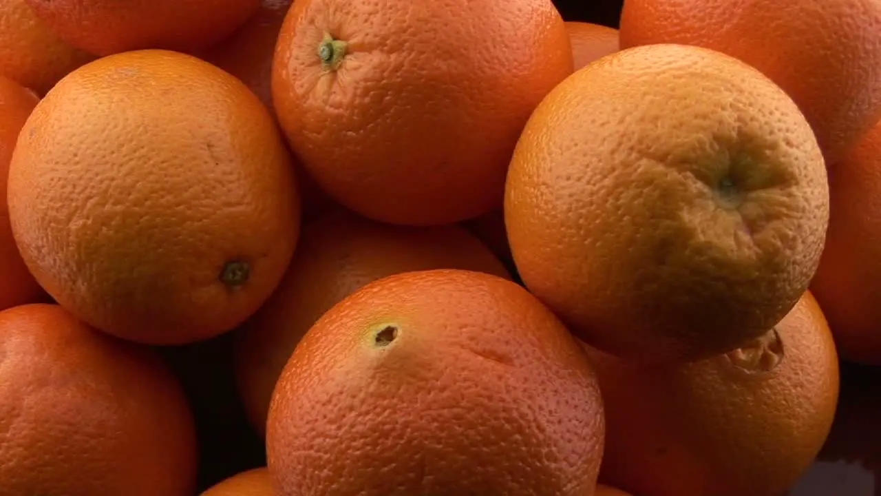 A pile of oranges sits on a table