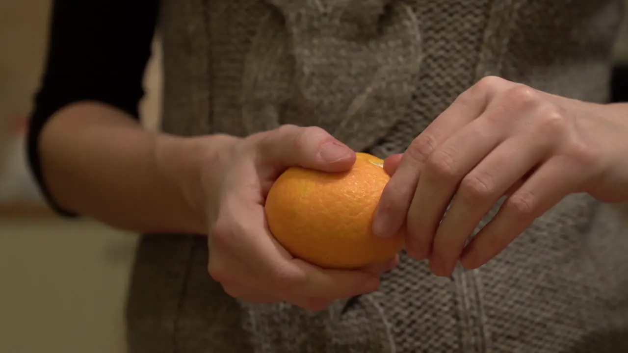 Woman peeling an orange mandarine close shot of hands