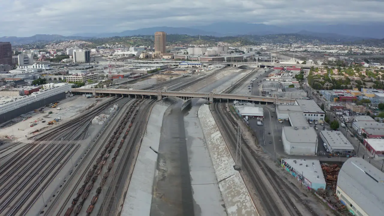 AERIAL Los Angeles River with Water on Cloudy Overcast Sky next to Train Tracks