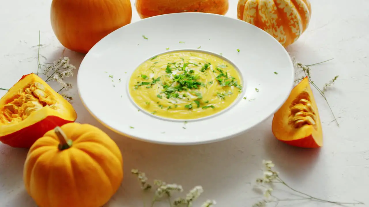 Soup in plate with pumpkins around