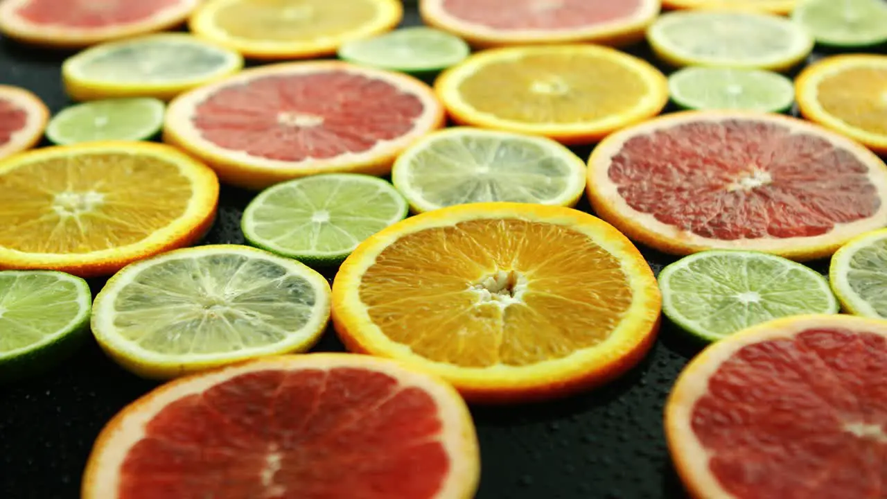 Slices of citruses on dark table 