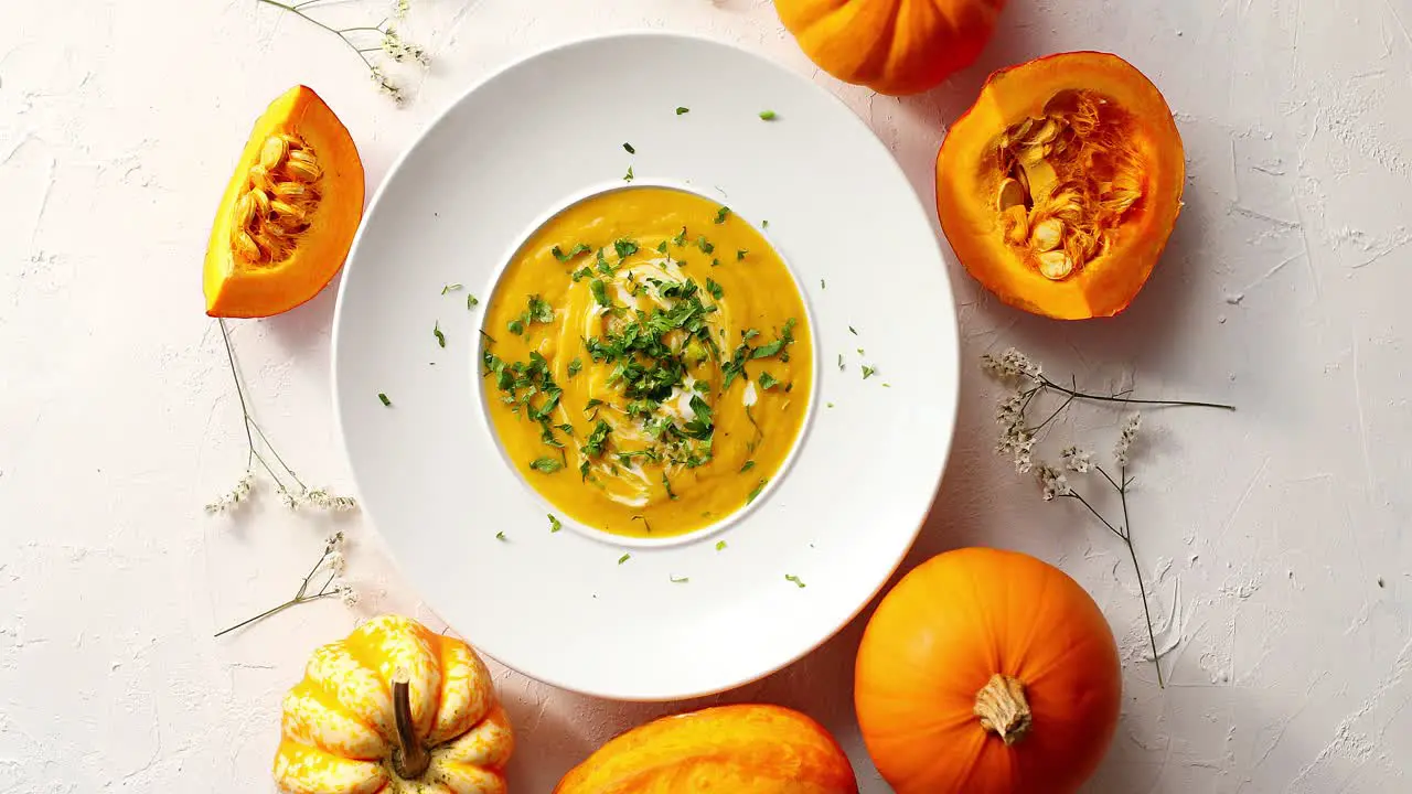 Pumpkin soup in plate with vegetables around