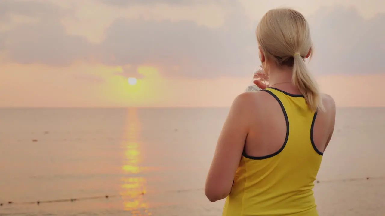 Fitness Woman Is Drinking Water From A Bottle It Stands In A Picturesque Place By The Sea At Dawn Re