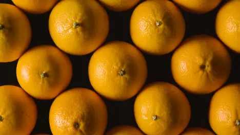 Overhead Studio Shot Of Oranges Revolving Against Black Background