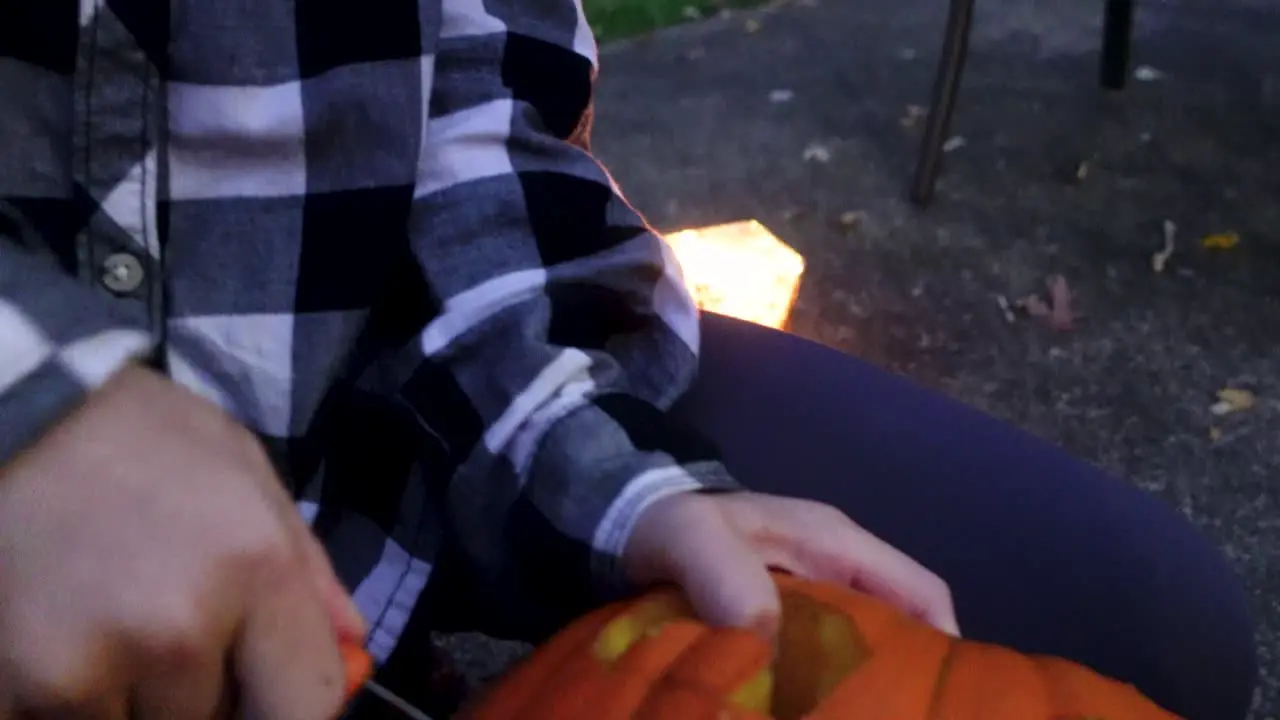 Close Up Of Excited Blondie Girl Carving Fast With knife Orange pumpkin Halloween