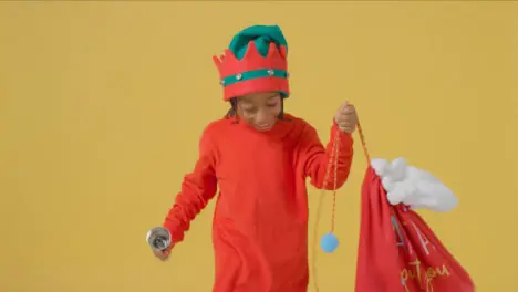 Young Boy Walking Holding Santa Sack and Bell