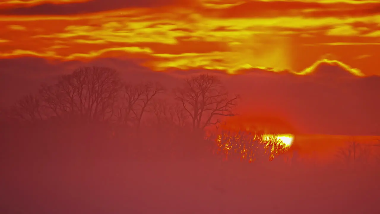 Time lapse shot of sun rising up behind burning sky with clouds in the morning close up Beautiful nature scene during autumn