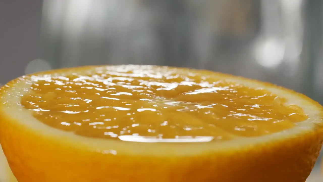 Macro shot of Orange juice falling on fresh orange slice Super slow motion