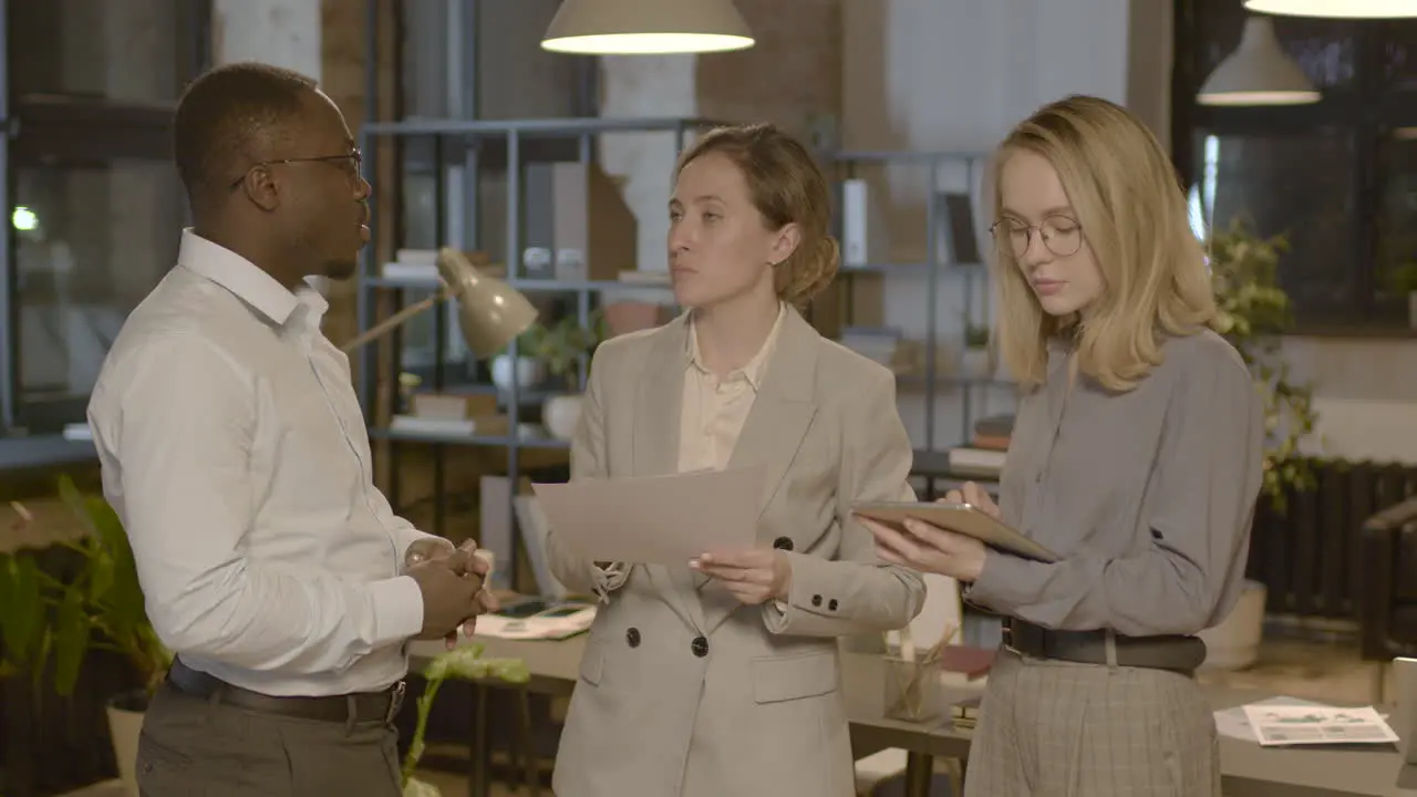 Group Of Three Employees Standing In The Office And Discussing Together About Business Strategy 1