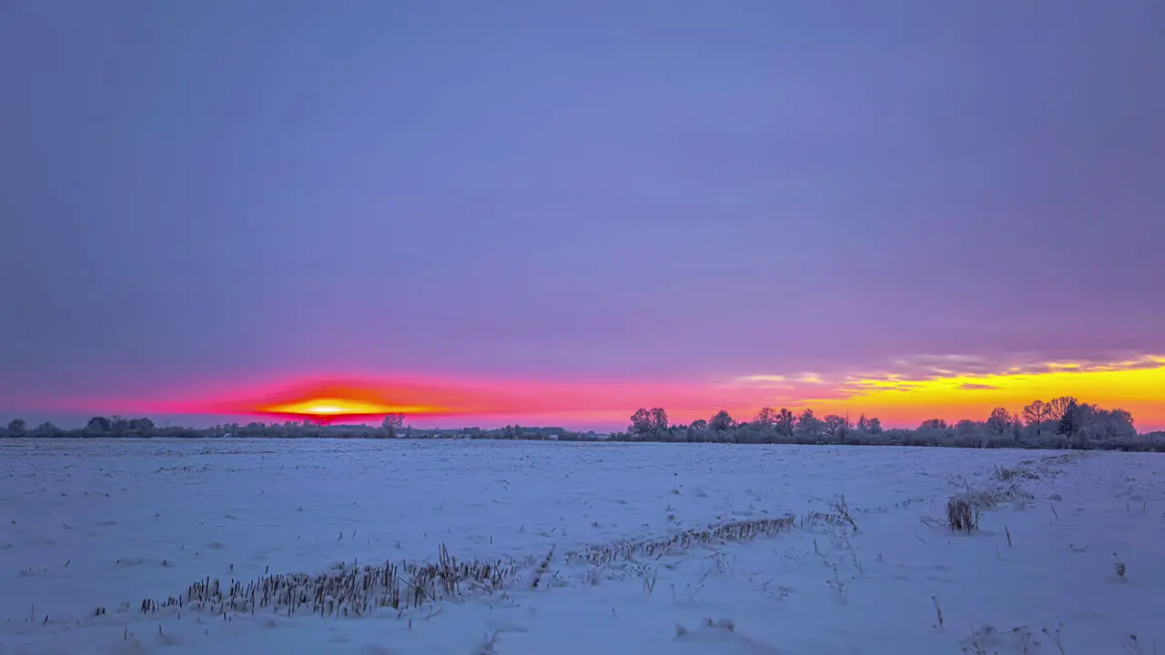 Time-lapse of orange sunrise in snowy winter wonderland landscape