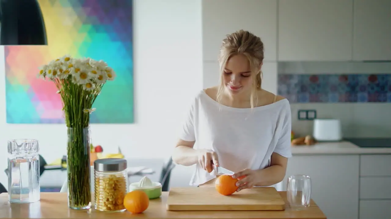 healthy woman cutting orange on wooden board Preparing morning breakfast