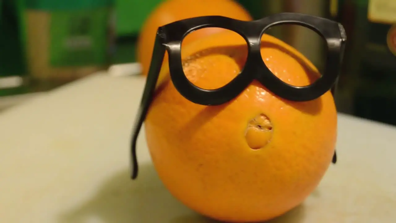 tracking shot of the orange with glasses smart looking orange for diet plan