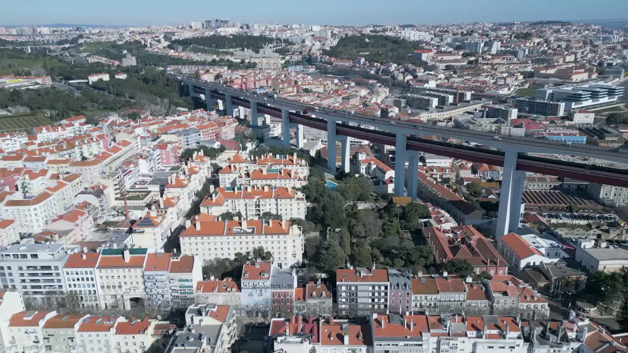 Aerial of houses with orange roof in Lisbon Portugal and suspended motorway pan right