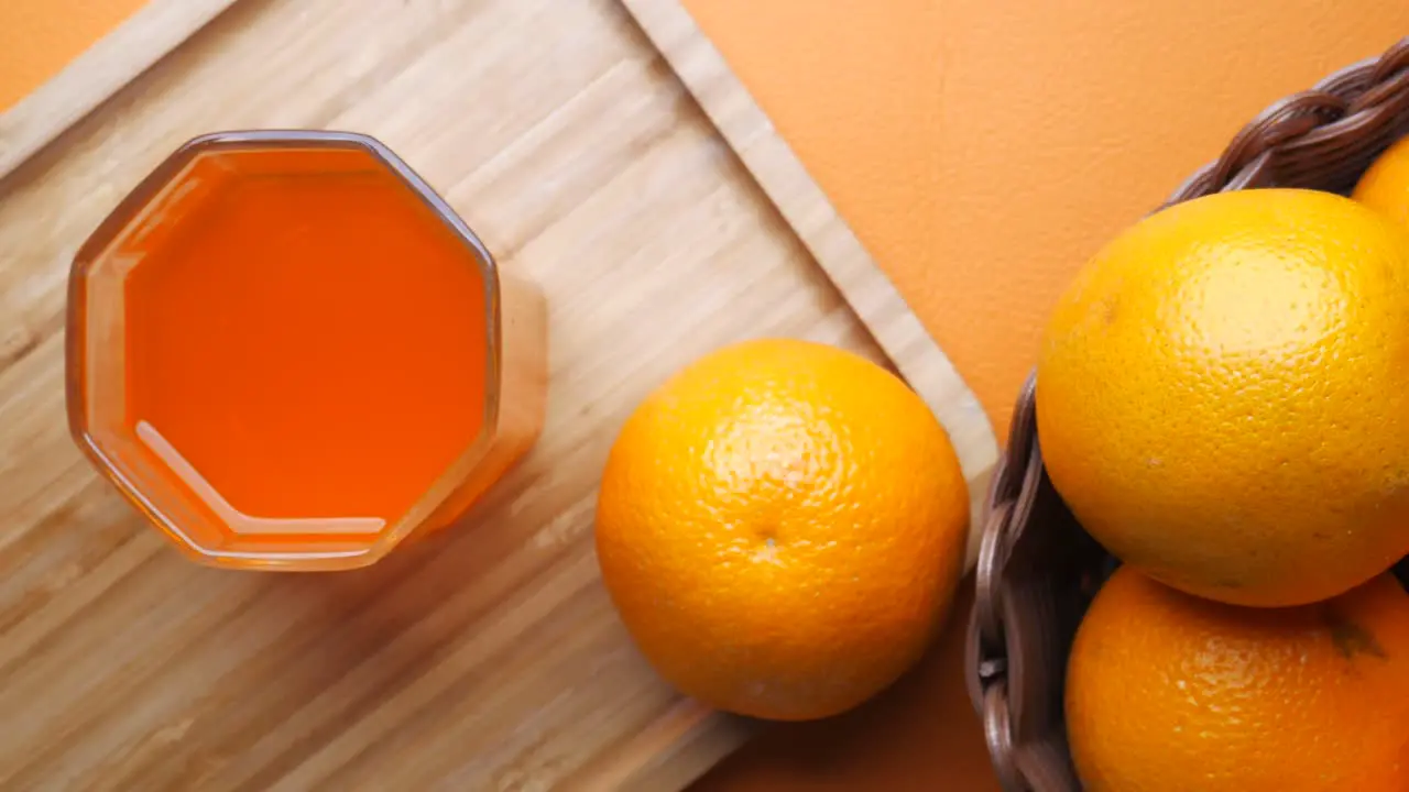 Pouring orange juice in glass on a background 