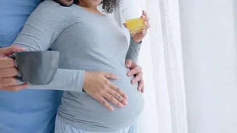 Pregnant couple and woman with orange juice