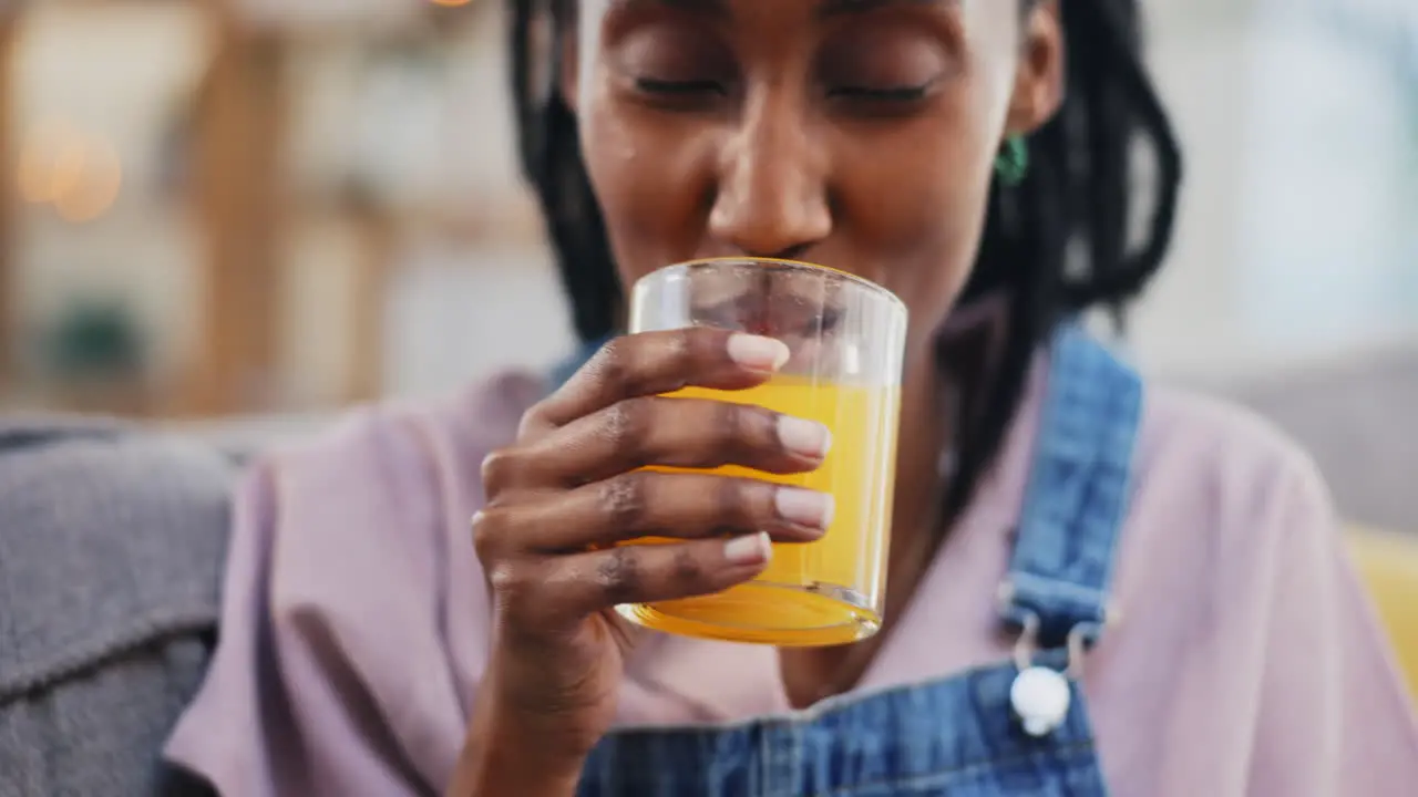 Happy black woman and orange juice in home living