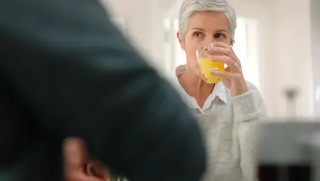 Healthy senior woman with orange juice talking