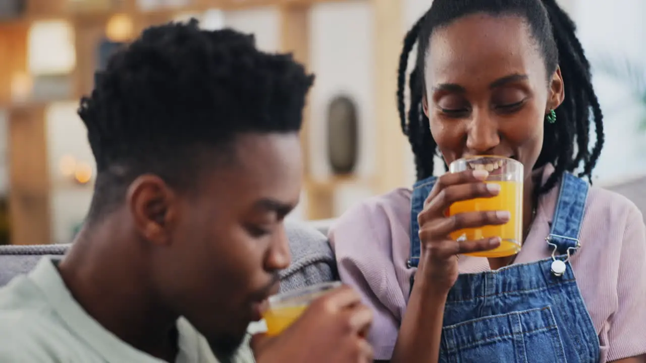 Happy black couple and orange juice in home