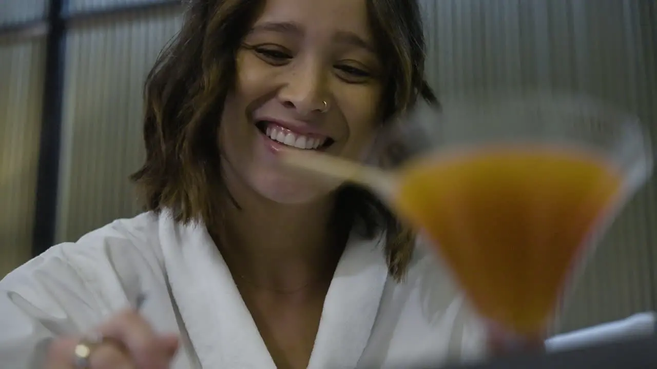 Slow motion shot of a beautiful female having breakfast with a glass of orange juice