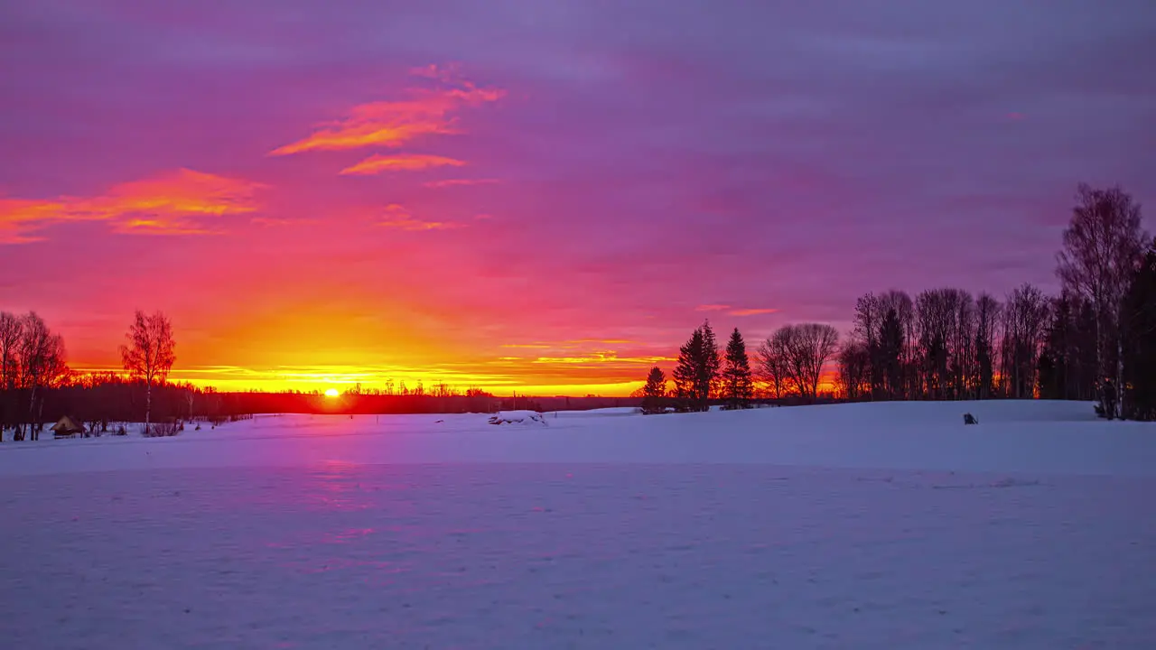 beautiful orange-red sunrise over an open winter landscape on a cloudy day