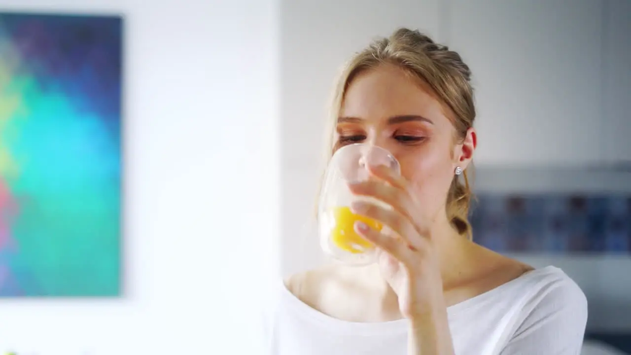 Beautiful girl drinking fresh orange juice from glass Close up happy woman