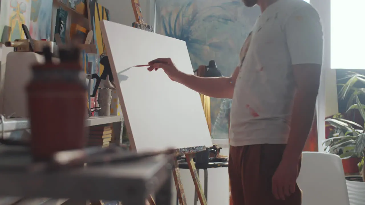 Creative Man Drawing Picture on Canvas in Art Studio