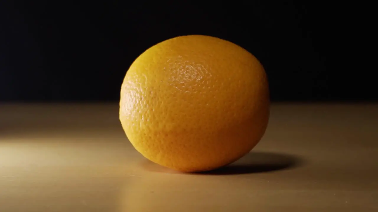 Beautiful orange on a table close up shot with a black screen background