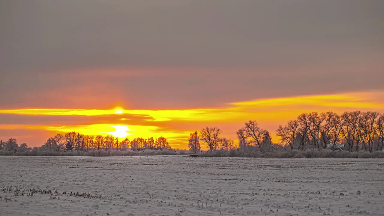 Time lapse of yellow orange sunset in the winter wonderland rural area