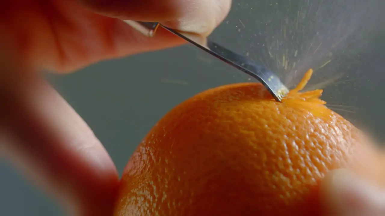 A Tool Runs Against the Skin of an Orange to Create Zest